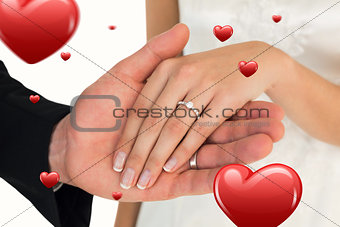 Composite image of cropped image of newly wed couple holding hands