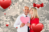 Composite image of handsome man holding paper heart getting a kiss from wife