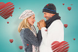 Composite image of couple in winter fashion embracing