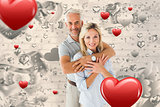 Composite image of happy couple smiling at camera and embracing
