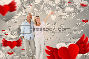 Composite image of smiling couple walking and pointing