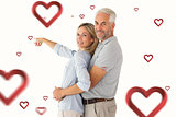 Composite image of happy couple smiling at camera and pointing