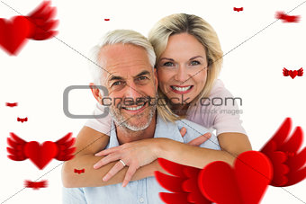 Composite image of smiling couple embracing and looking at camera