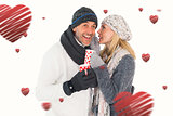 Composite image of happy couple in winter fashion holding mugs