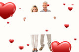 Composite image of happy couple holding large poster