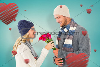 Composite image of attractive man in winter fashion offering roses to girlfriend