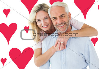 Composite image of smiling couple embracing and looking at camera