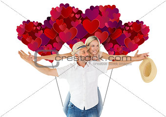 Composite image of happy man giving his partner a piggy back