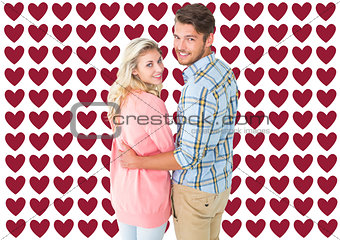 Composite image of attractive couple turning and smiling at camera