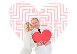 Composite image of older affectionate couple holding red heart shape