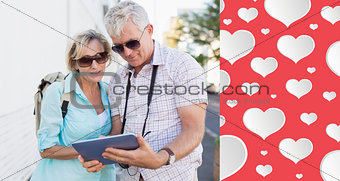 Composite image of happy tourist couple using tablet in the city