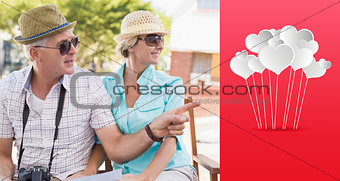 Composite image of happy tourist couple looking at map in the city