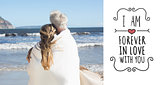 Composite image of couple wrapped up in blanket on the beach looking out to sea