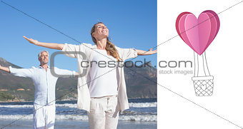 Composite image of happy couple standing with arms outstretched at the beach
