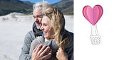 Composite image of carefree couple hugging on the beach in warm clothing