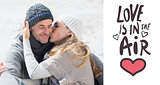 Composite image of attractive couple on the beach in warm clothing