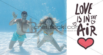 Composite image of cute couple smiling at camera underwater in the swimming pool
