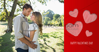 Composite image of smiling couple standing and embracing in park