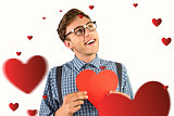 Composite image of geeky hipster holding a heart card