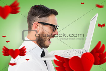 Composite image of geeky frustrated businessman looking at his laptop