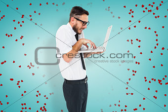 Composite image of geeky businessman using his laptop