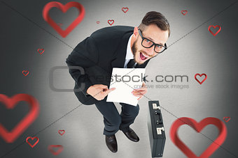 Composite image of geeky smiling businessman showing paper