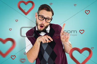 Composite image of geeky hipster in sweater vest pointing