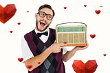 Composite image of geeky hipster holding a retro radio