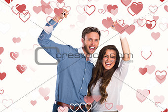 Composite image of happy young couple cheering