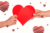 Composite image of hands holding red heart
