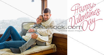 Composite image of couple in winter clothing sitting against cabin window