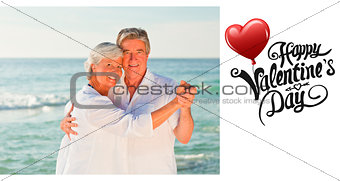 Composite image of mature couple dancing on the beach