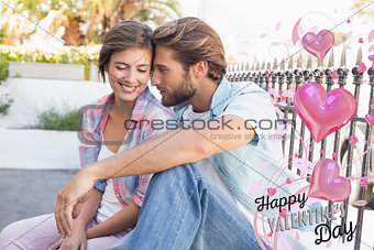 Composite image of happy couple sitting and cuddling