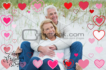 Composite image of romantic senior couple relaxing at beach