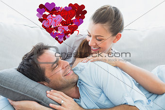 Composite image of cheerful couple relaxing on their sofa smiling at each other