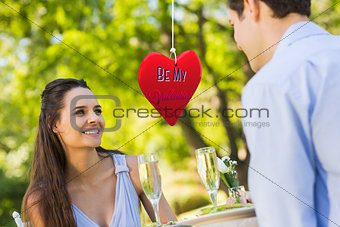 Composite image of couple with champagne flutes sitting at an outdoor café