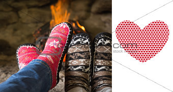 Composite image of close up of romantic legs in socks in front of fireplace