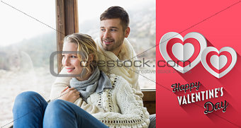Composite image of couple in winter wear looking out through cabin window
