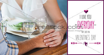 Composite image of couple holding hands at dinner