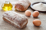 Homemade bread ciabatta on the table. Olive oil, eggs and flour