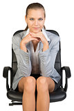 Businesswoman on office chair, with head reclined upon her hands