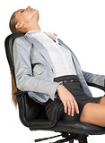 Businesswoman resting in office chair with her head thrown back 