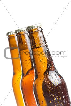 three bottles of fresh beer with drops, isolated