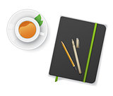 Notebook with pen and cup of tea