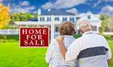 Happy Senior Couple Front of For Sale Sign and House
