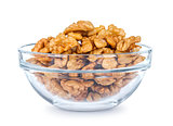 a lot of walnuts in a glass bowl on a white background