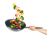 Falling vegetables in frying pan on an isolated white background