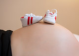 Pregnant woman with a pair of baby sneakers