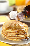 Pouring Maple Syrup on Pancakes