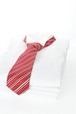 Pile of white shirts with red tie. Business concept